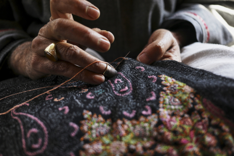 Hands weaving a tapestry
